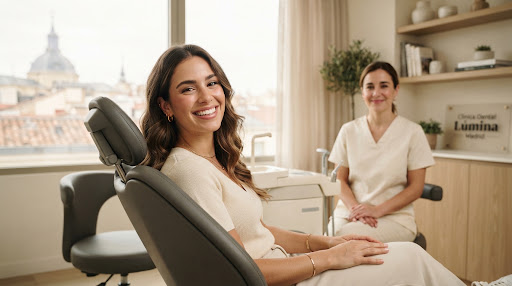 Paciente sonriendo en la sala de una clínica dental luminosa y minimalista en Madrid